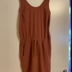 Klänning Patagonia  - Lättviktsklänning i snabbtorkande material. Observera att bild 4 och 5 endast är för att visa hur klänningen sitter på.  Klänningen är endast provad, så den säljes i nyskick. Nypris 999kr  Färgen är terrakotta.