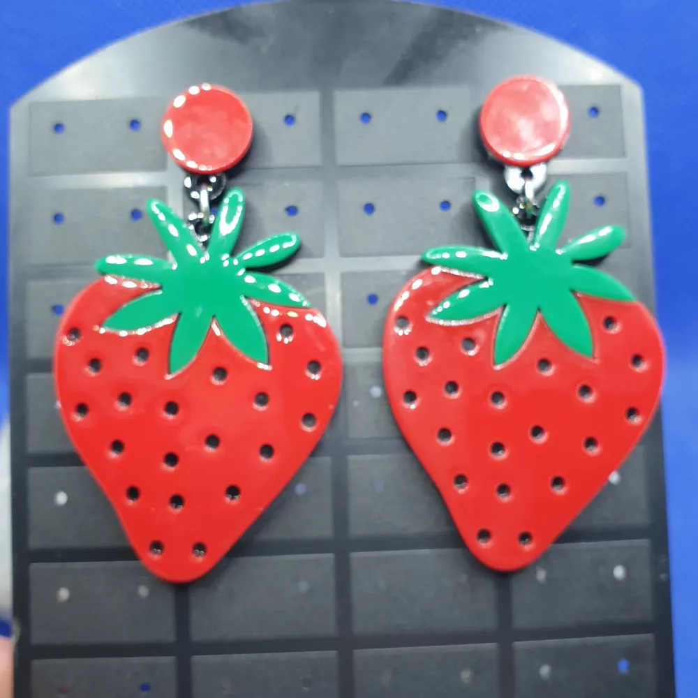 Den här örhänget föreställer jordgubbar / Jordgubbe med måtten är ca7 ×4 cm. Material av metall och akryl. Otroligt snygga örhängen av hög kvalitet.  Grymt snygga örhängen, oanvända, nyskick. Accessoarer.