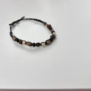 Jättefint brunt armband med stenar i olika färger som är justerbar!!! Aldrig använd