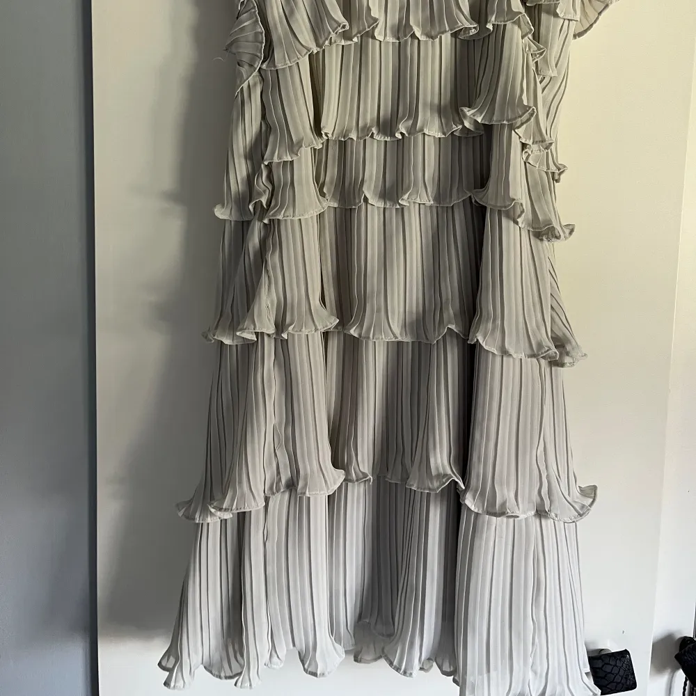 Otroligt fin klänning med volanger och fina detaljer! Går att ha exelbandslös och det finns en gömd dragkjedeja på ena sidan.🌸 ljusljus grå/vit. Klänningar.