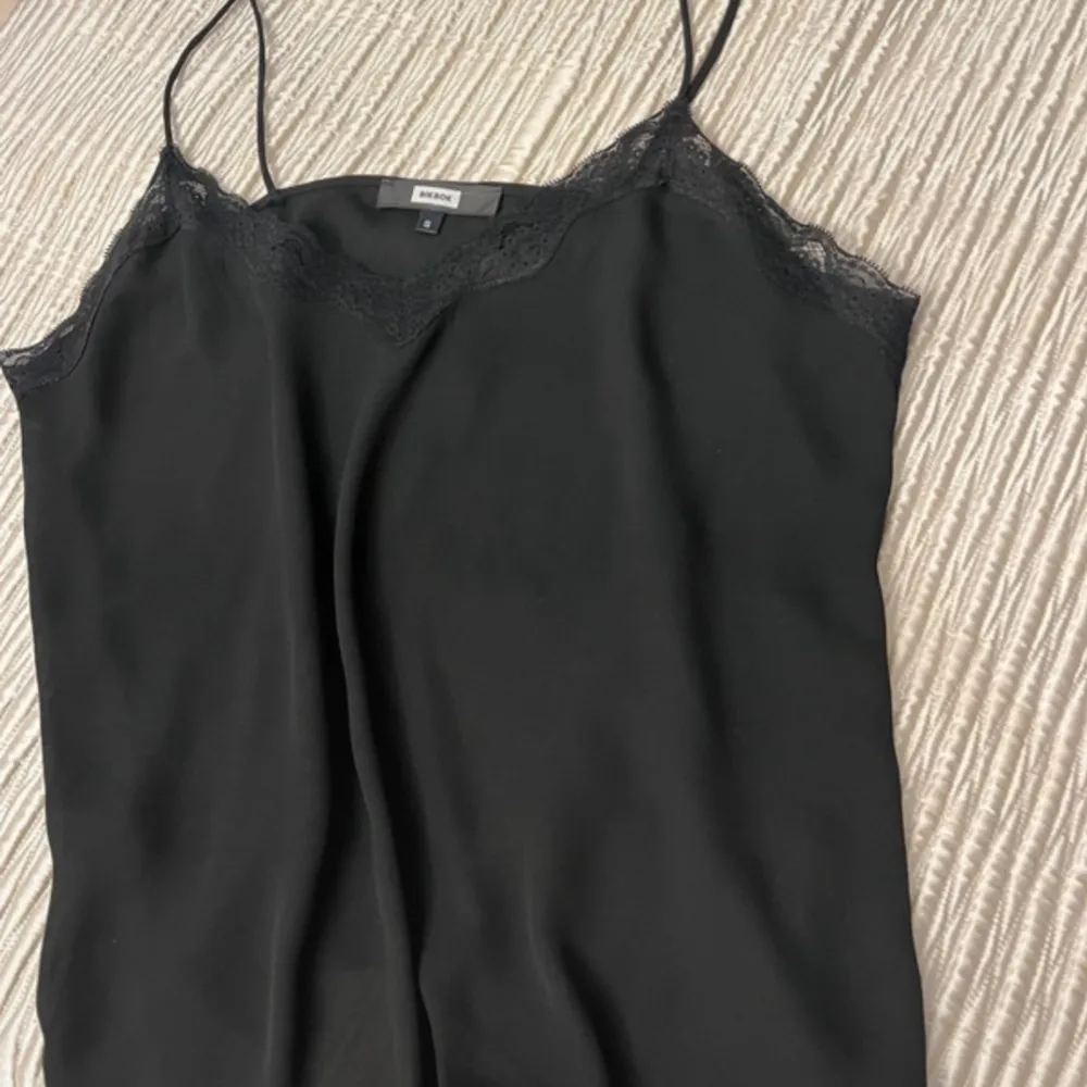 Simple and elegant black top. Works with a jacket for office wear and with a glittery coat for evening I have worn it only a couple of times On the label it’s a size small but fits a size 38 perfectly too. Mint condition . Toppar.