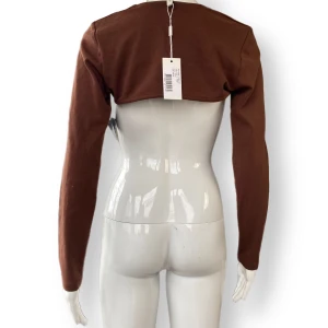 Långärmad  - Lappen från Nelly finns kvar. I toppenskick! Jättesnygg att dra över en snygg topp. Storlek M. Mörkbrun. 