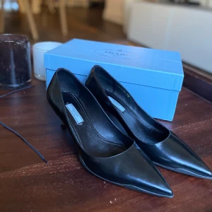 Prada pumps - Säljer dessa otroligt snygga, klassiska Prada pumps som jag fick i julklapp men tyvärr var för stora 🥹 Kommer med tillhörande kartong och dustbag. Aldrig använda av mig eller tidigare ägare. Köpta från Vestaire. Stora i storlek.