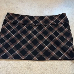 Fin brun rutig kjol! - Super fin rutig kjol ifrån H&M! Säljer för att den är för stor för mig. Köpt i 2022 tror jag och den är inte använd 