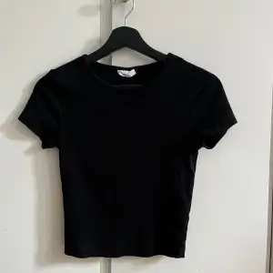 Vanlig svart lite kortare t-shirt. Köpt på gina tricot i storlek s.
