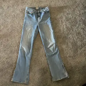 Ljusblåa jeans i storlek S med slits. Köpta på lager 157.