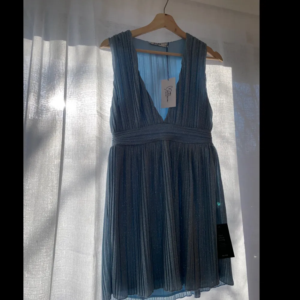 Ljusblå glittrig kort klänning ifrån Moa Matssons kollektion med NA-KD i storlek S. Aldrig använd med lapparna kvar. . Klänningar.
