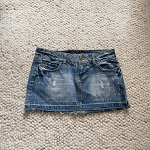 Lågmidjad jeanskjol  - Snygg lågmidjad jeanskjol. Midjemåttet är ca 38cm rakt över.