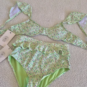 ASOS grön blommig bikini - Otroligt söt bikini med volanger och högmidjad bikiniunderdel. Ny med tags kvar. Storlek 36 i båda delar.