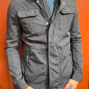 Field jacka - Säljer denna stilrena fieldjacka som knappast är använd och ser sprillans ny ut! Det är storlek M men sitter som en S. Är öppen för bud!