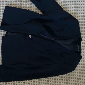 Mörkblå kavaj - Mörkblå kavaj feån ginatricot, passar XS/XXS  står strl 40 på kavajen men tror den kan ha krympt i tvätten. 