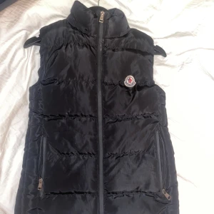 Snygg moncler väst - sparsamt använd, jättesnygg men använder inte längre. Finns luva att få med oxå.