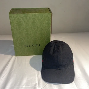 Gucci keps  - Jag har bestämt mig för att sälja min svarta Gucci keps eftersom jag inte längre använder den. Storleken är M och jag har haft kepsen i runt 2-3 månader. Den är i väldigt bra skick!