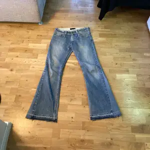 Ljusblå vintage bootcut/flare jeans i helt okej skick. Väldigt slitna längst ner (hör av dig om du vill ha bild), knappen sitter löst och hål i fickorna. Skulle säga att dem är som storlek 31.