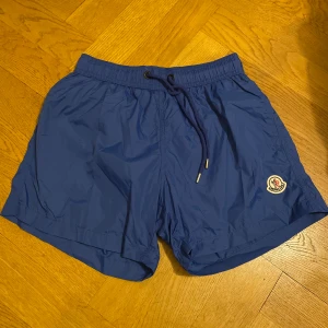 Moncler badbyxor(Blå) - Hej! Säljer ett par helt oanvända Moncler badbyxor i storleken ”M” men badbyxorna passar i ”XS” perfekta nu inför sommaren med sol och bad ☀️🌊