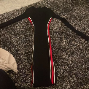 Ribbat stickat kläning i skims  - Mjuk  Inte använd  Inte min stil numera  Skims liknade, sitter som en smeck Svart med röda och vita rämar på sidan 