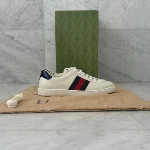 Gucci ”Ace” Sneakers - Säljer nu dessa riksfeta Gucci ”Ace” Sneakers. Skorna är helt nya och aldrig använda ~ 10/10 skick. Box, dustbags och extra skosnören följer med köpet - Nypris: 8000 kr - Storlek: UK 9 ~ EU 43 - Hör av er vid minsta fråga eller fundering :)