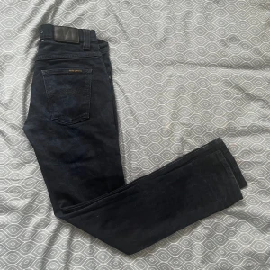 Nudie Jeans Grim Trim - Säljer nu dessa stiliga svarta jeans från Nudie som är perfekta för vårsäsongen. Säljer pga för liten storlek men hade annars behållt. Skick: 9/10. Skriv vid funderingar.