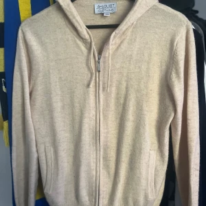 Stickad zip hoodie beige - Zip hoodie från Ahlquist Clothing med en mix av bl.a. cashmere och merinoull. Väldigt trendig och bekväm.