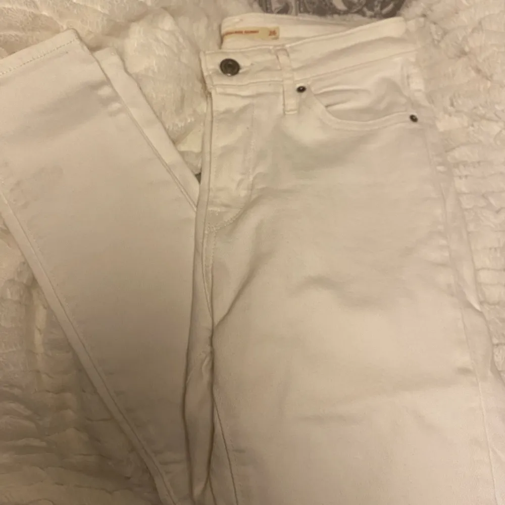 Säljer ett par vita tajta jeans från Levis. De är i storlek 26 och är i bra skick, hittade dock en liten fläck på smalbenet som syns på sista bilden. . Jeans & Byxor.
