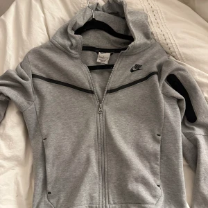 Nike tech tröja (har även byxorna om intresse!) - Grå niketech tröja, inte andvänd alls mycket. Bra skick! Storlek M barn (137-147cm). Kan mötas upp i sthlm eller posta. 