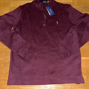 Ralph Lauren half zip - Säljer denna Ralph Lauren tröja som är helt ny och aldrig använd. Tröjan är i storlek L och är riktigt stilren!