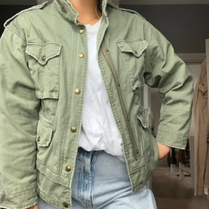 Vårjacka ZARA grön tygjacka - Grön tygjacka från zara, storlek XS men är oversize i modellen så skulle säga beroende på hur man vill att den sitter S / liten M. Detaljer på ryggen. 