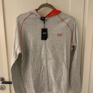 Hugo Boss zipper  - Helt ny Hugo Boss tröja, endast uppbackad för att fotas. Det är en tunnare bomulls hoodie, som man kan ha över en t-shirt eller stängd som den är. Sjävklart 100% äkta. 