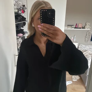 Stickad tröja med v rigning - Svart stickad tröja med V rigning från Ginatricot. Endast använt ca 3 ggr, alltså typ nyskick. 