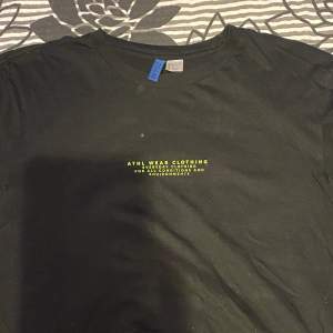 En svart t-shirt som är köpt ifrån HM, med tryck på fram- och baksida. Den är använd många gånger men har bra skick