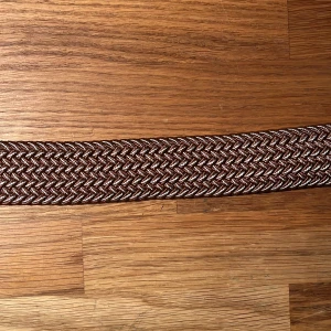 Flätat bälte  - Säljer det här nya och oanvända flätade bältet. Hela bältet bortsett från metallbiten är ca 98 cm långt, men kan stretchas ut till en större storlek. Pris: 69 kr