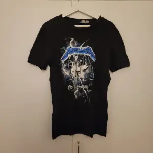 En svart Metallica T-shirt i fint skick. Tryck på både framsidan och baksidan. Storlek XS, men passar även till de som har storlek S. 