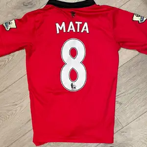 Säljer detta äkta Manchester United hemmaställ ifrån säsongen 2012/13, med guldiga Premire League Symbole på armarna, med Juan Mata #8. Storleken är M, men passar även S. Det är bra skick på tröjan, förutom AON loggan som har lostnat lite.Nypris 1200