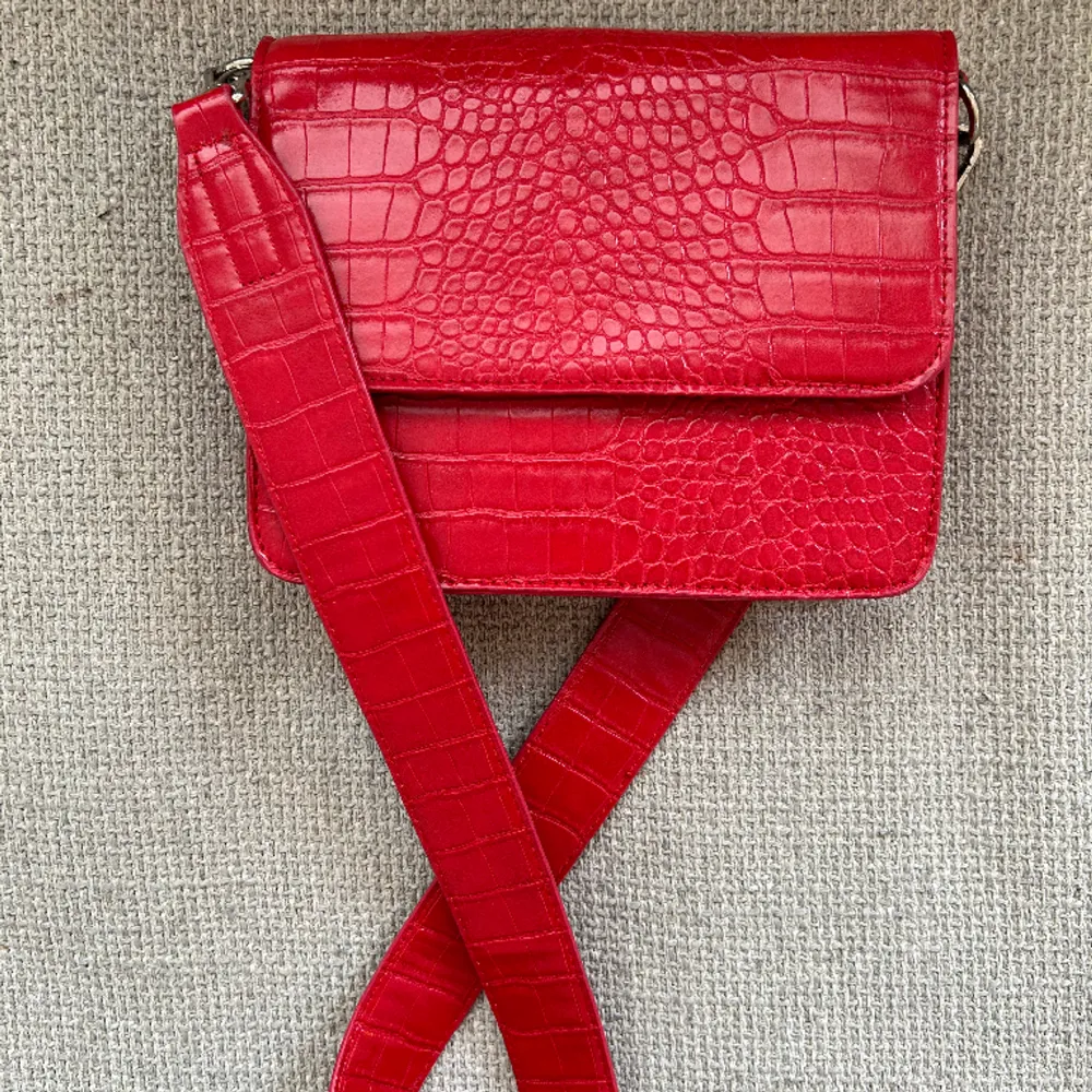 Säljer en röd väska från ginatricot då den inte längre kommer till användning. Använt ett fåtal gånger så den är i bra skick!. Väskor.