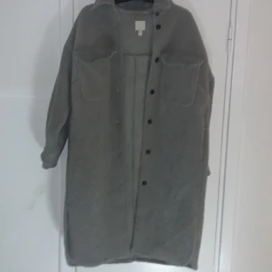 Oversize kappa  - Oversize kappa grå ull utan på och mocka på insidan. Den håller en varm. Något enstaka cigarett märke på nedre delen
