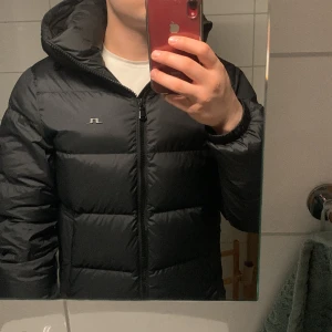 J.Lindeberg jacka  - Tjena,  Säljer en fet dunjacka från J. Lindeberg i svart färg. Nyskick, använd i 1-2 månader inga defekter eller tecken på användning  Nypris 4800. Säljer för 3200 eller bud