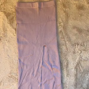 En lila maxi kjol, slutar över knäna, har en liten slits