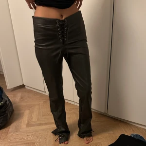 Skinnbyxor med knyten - Jättefina skinn imiterade byxor i bootcut. Från Zara i storlek M. Nya - prislappen är kvar. Nypris:560kr