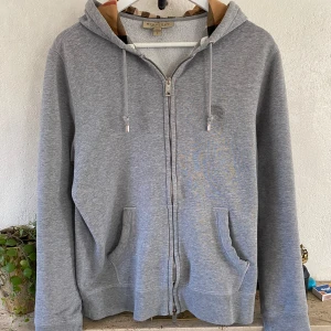 Burberry zip hoodie  - |Tja säljer nu denna burberry hoodie då den har blivet för liten| storlek L men sitter som M| tröjan är i använt skick och de finns några hål på baksidan men inget som på verkar användning| vid frågor eller funderingar är de bara hör av sig| 