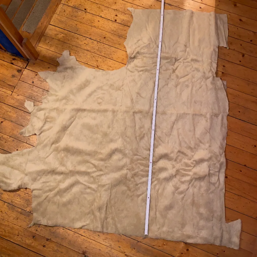 Pälsliknande tyg som det tidigare gjorts käpphästar av. Övre delen 60x40 cm. Nedre delen 110x100 cm. Maxlängden som kan fås ut är 140 cm (40+100). Övrigt.