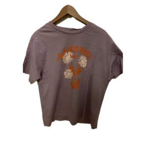 Lila t-shirt med orangea blommor på från monki. Bra skick.