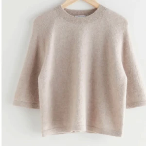 & Other Stories Stickad Tshirt - Supertrendig stickad tshirt från & Other Stories i alpacka i färgen beige. Använd cirka 3 gånger. Nypris; 690kr. Klicka på köp nu!