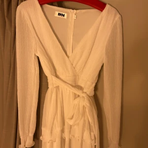 Studentklänning  - in vit klänning som man har ett band i midjan som man själv knyter hur man vill ha det.  Storlek 36, sitter bra på mig som är 1,67 lång och är normal i storlek.