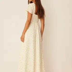 Ankellång vit klänning med små gula blommor. Sååå söt! Nypris 499kr. Aldrig använd. Däremot tvättad 1 gång.