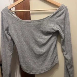 Grå långärmad tröja - Snygg med bred urringning så lite off shoulder och inte crop top men når precis under naveln