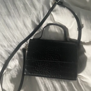 Svart handväska 💕 - Superfin hand väska. Stil ren. Man kan ha den som en Axel väska om man vill det.  Bandet går att ta av. Mangnet spänne och fack i sig. Knappt använd och i ett ny sick💗