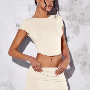 Beige set  - Snyggt set med öppen rygg. Det är shorts i kjolen. Aldrig använt. Storlek xs