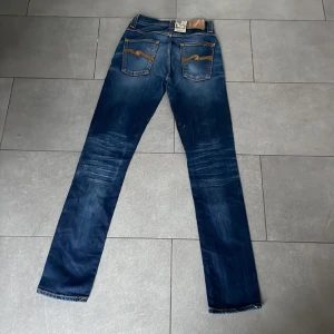 Nudie Jeans ”Grim Tim” - Jeans av Nudie Jeans Co. i modellen ”Grim Tim”. Aldrig använda, tag sitter kvar. Snygg indigo färg. Nypris ca 1599:- Vid frågor är det bara att DMa ;)
