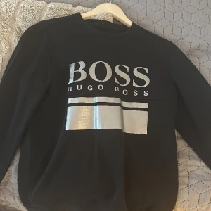 Boss tröja - Svart boss tröja. Väldigt stilig och passar perfekt med svarta, blåa, gråa jeans. Nypris är 1600 kr. Säljer pga att jag bytt stil. Pris kan diskuteras