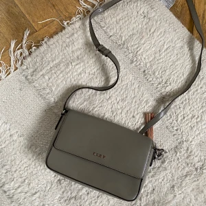 DKNY väska - Säljer min fina och praktiska DKNY väska (äkta). Kommer inte till användning längre. Färgen har lossnat lite från märket men inget som syns tydligt. 